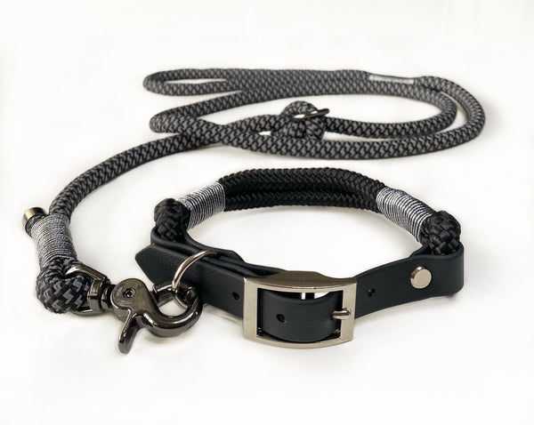 Sort hundehalsbånd med matchende hundesnor i reflekterende reb og sort kunstlæder.